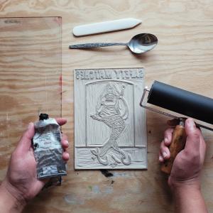 Lino print with artists hands 