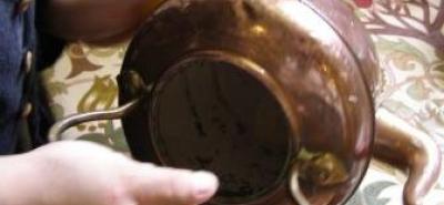 Image of a pupil polishing a brass teapot