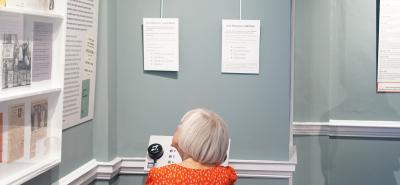 person sat at oral history listening station in a museum exhibition