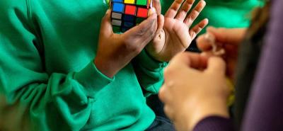 childs hands playing with a rubiks cube