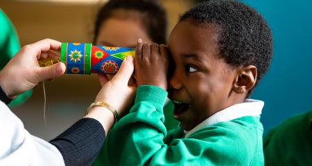 School kid looking into kaleidoscope