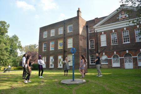 People on a tour viewing a sculpture