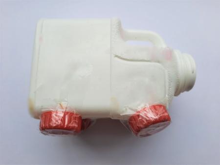 Milk bottle on side with four bottle top feet