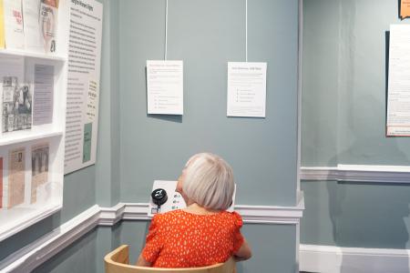 person sat at oral history listening station in a museum exhibition