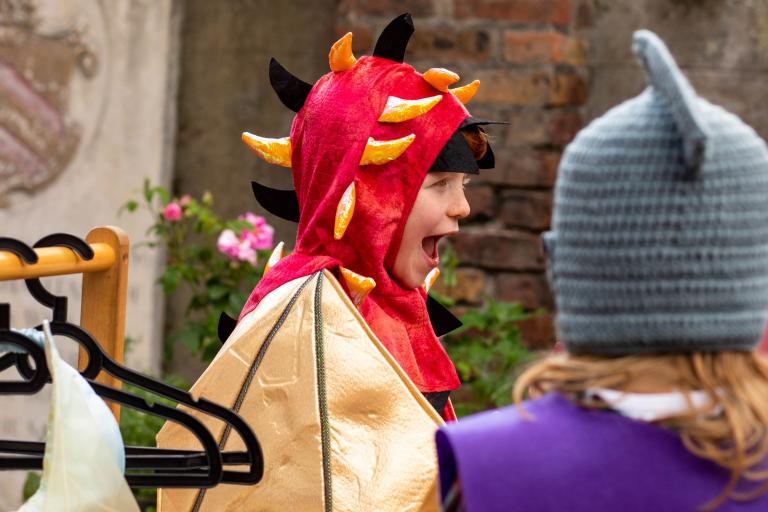 Children dressed up as a dragon and knight outside Bruce Castle Museum